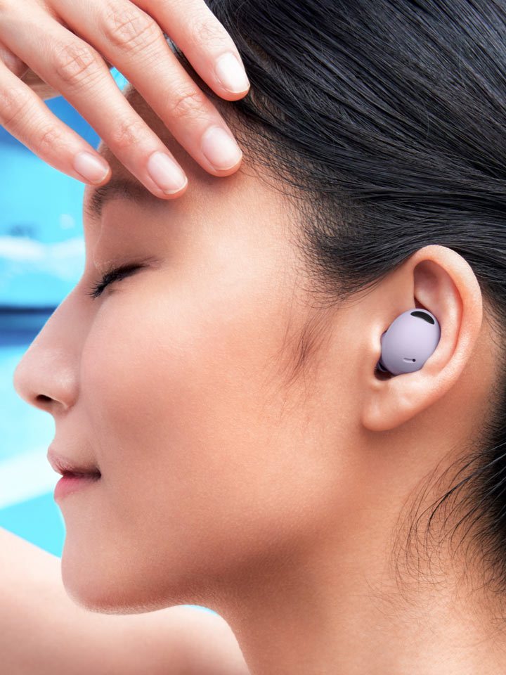A lifestyle shot of a woman’s ear that has a Galaxy Buds2 Pro earbud inside.