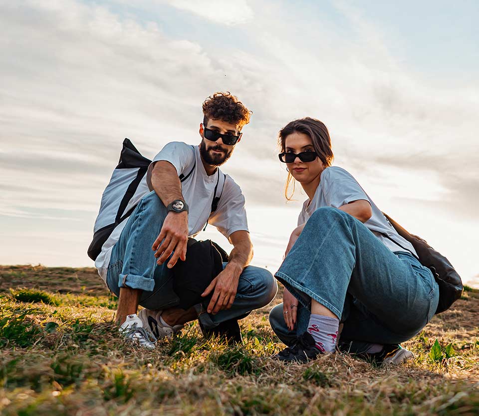 Two individuals pose for a low-angle photo from a distance using Galaxy Watch5 Pro to control the smartphone camera.