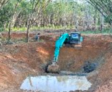 Excavator working on soil and waterway restoration in a forested area.