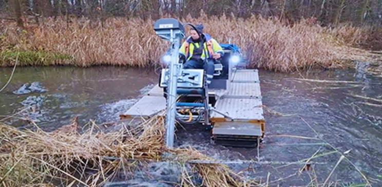 Worker checks monitoring equipment on a wetland platform.