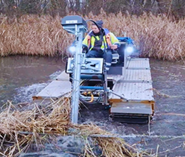 Worker checks monitoring equipment on a wetland platform.