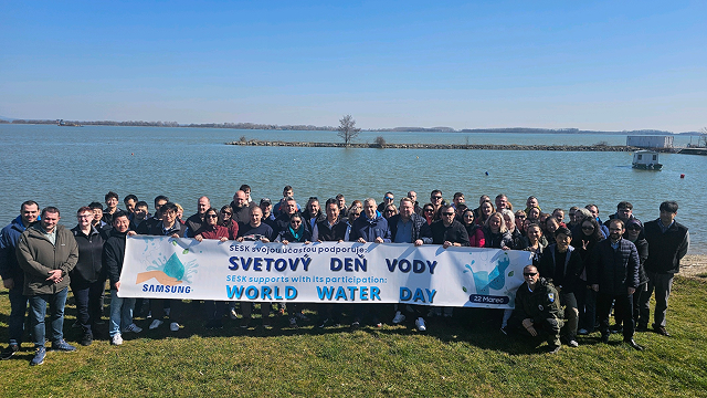 Samsung Electronics employees and local participants pose for a group photo by the river while holding a banner celebrating World Water Day.