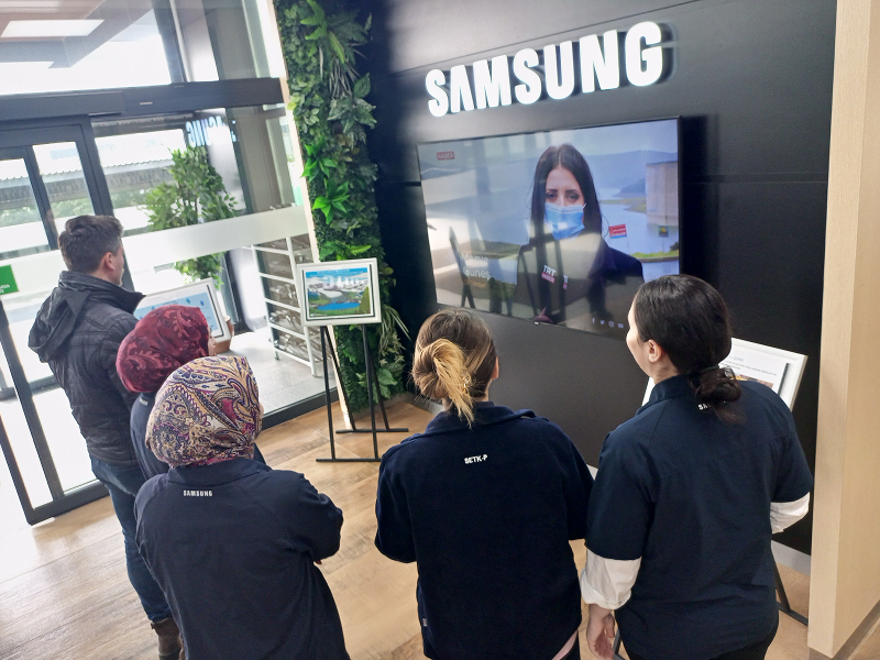 Samsung Electronics employees watch a water-saving campaign video displayed on a screen inside the company building.
